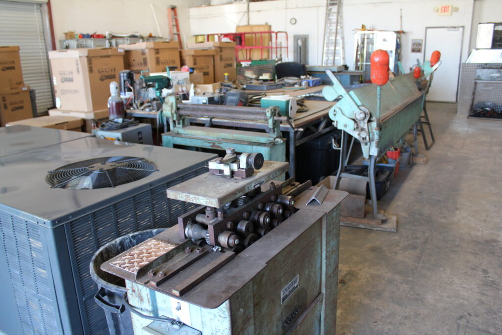 Sheet metal fabrication equipment and an HVAC unit in the workshop of Expert Air Conditioning & Heating in Las Vegas, NV.