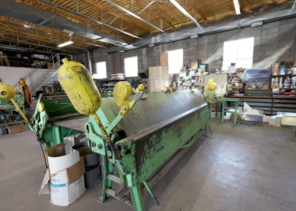 Interior view of the sheet metal fabrication workshop with bending machines at Carlsbad Heating & Cooling in Carlsbad, NM.