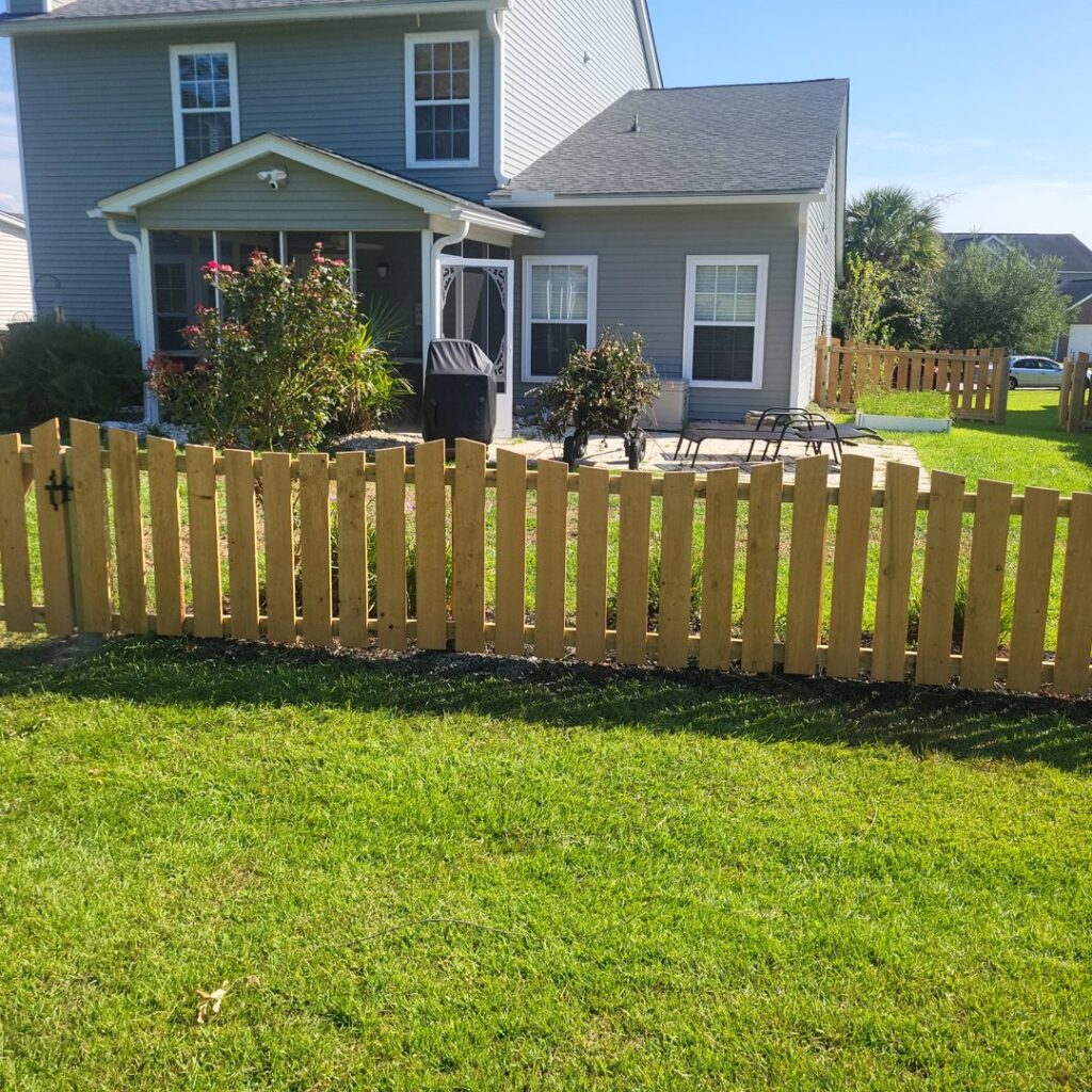 A short wooden picket-style fence with a gate installed by JB FENCE Brothers company llc in North Charleston, SC.