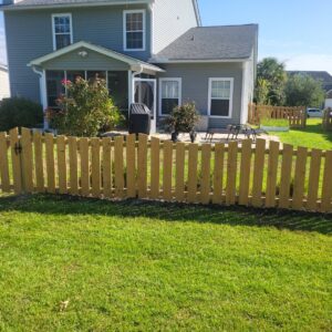 A short wooden picket-style fence with a gate installed by JB FENCE Brothers company llc in North Charleston, SC.