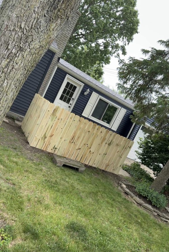 A short wooden privacy fence section installed next to a house by Final Touch Fencing LLC in Macomb Township, MI.