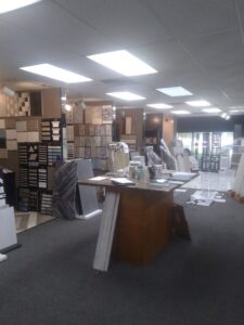 A wide view of the showroom featuring a large carpeted area and various tile displays at Palmetto Tile Columbia in Columbia, SC.