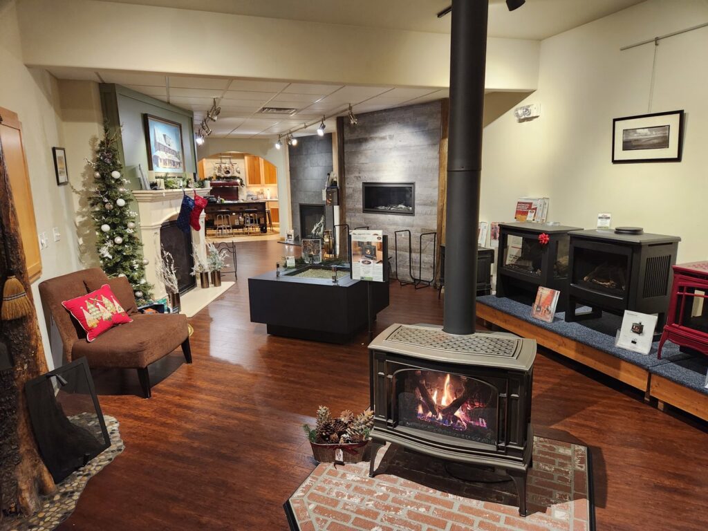 A showroom display featuring various wood stoves and fireplaces at Wood Stoves For Sale in Fairbanks, AK.