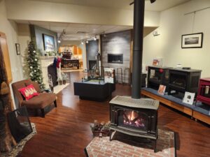 A showroom display featuring various wood stoves and fireplaces at Wood Stoves For Sale in Fairbanks, AK.
