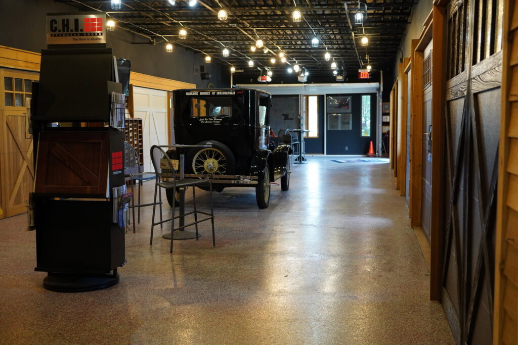 A showroom featuring a vintage car and various garage door displays from Garage Doors Of Indianapolis in Indianapolis, IN