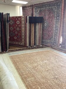 A showroom featuring both hanging and floor rugs, showcasing the selection at Woven Treasures, Inc in Mobile, AL.