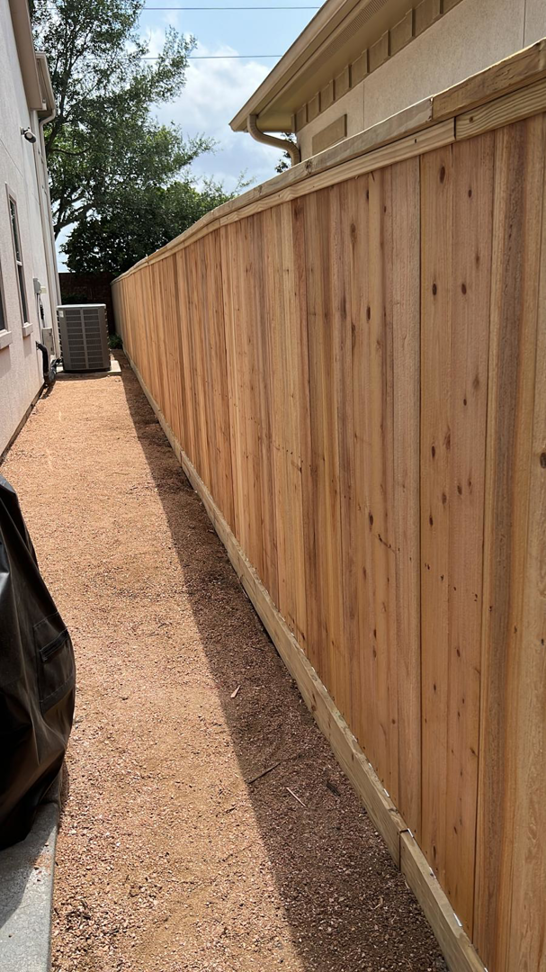 A new wooden privacy fence installed along a side yard by Alexi's Handyman Services in Indianapolis, IN.