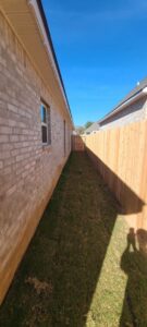 A new wood privacy fence installed in a narrow side yard of a residential property by C & M Affordable Fence, LLC in Haughton, LA