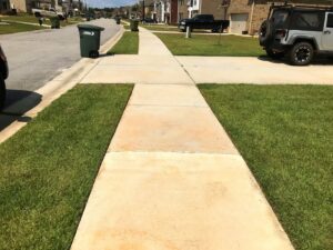 Neatly edged and mowed grass along a sidewalk and curb by Kirby's Lawn Care Service in Franklinton, LA.
