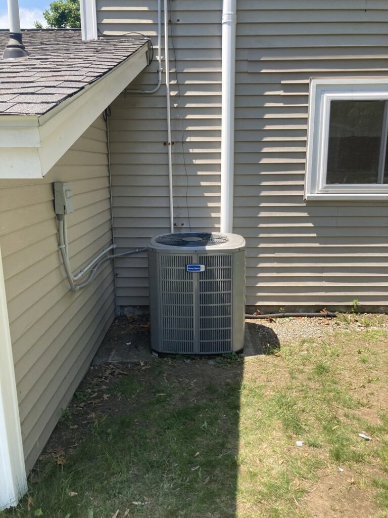 A single outdoor air conditioning unit installed next to a house by Freedom Air Mechanical Contractors LLC in Everett, MA.