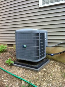 A single outdoor Carrier air conditioning unit installed next to a residential building by 495 HVAC in Annandale, VA.