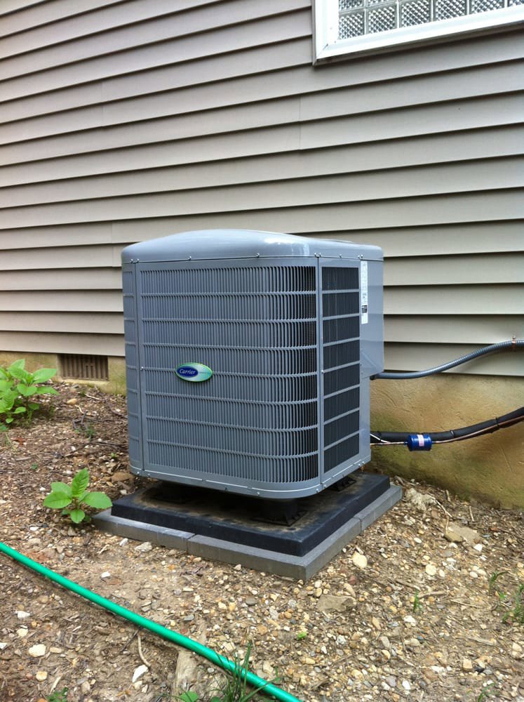 A single outdoor Carrier air conditioning unit installed next to a residential building by 495 HVAC in Annandale, VA.