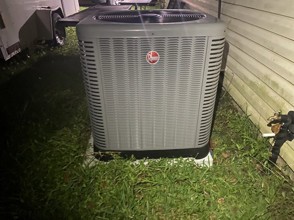A single Rheem outdoor air conditioning unit installed at a property by Total Living Comfort in Irvington, AL.