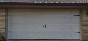 A single white garage door with decorative hardware installed by Tulsa Garage Door Doctor LLC in Tulsa, OK