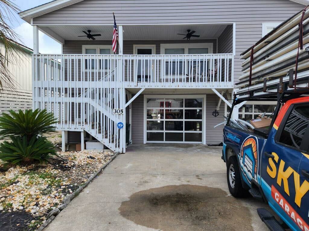 Skylift Garage Doors truck parked in front of a house with a modern glass garage door, indicating installation in Knoxville, TN