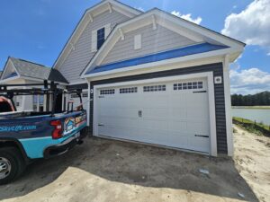 Skylift Garage Doors truck parked next to a newly installed white garage door on a house under construction in Knoxville, TN