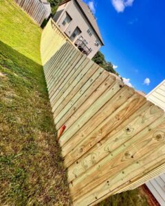A wood privacy fence expertly installed on a steep slope by Hawk Fences LLC in Johns Creek, GA.