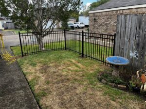 A small black ornamental iron fence enclosing a front yard area by Dallas' Custom Carpentry in Alexandria, LA.