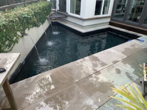 A small, clean swimming pool with elegant water features, serviced by Pool King in Southhold, NY.