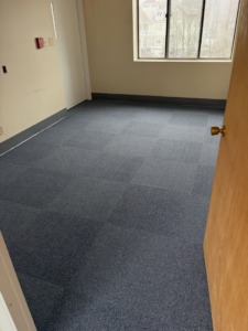 A small office room showcasing new blue carpet tile flooring installed by Basics Flooring in Natick, MA.