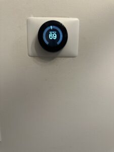 A smart thermostat displaying 'HEAT SET TO 69' on a wall, installed by On Call Plumbing, Heating & Air in Columbia, SC