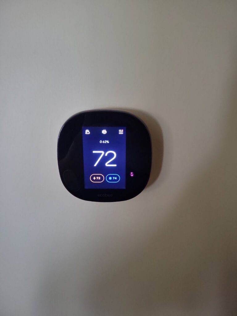 A modern smart thermostat installed on a wall by Comfort Hounds Heating & Cooling in Raleigh, NC.