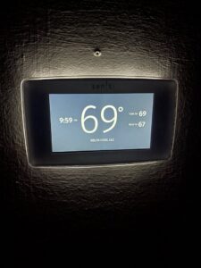 A smart thermostat displaying "Delta Cool LLC" and current temperature settings, showcasing a professional installation by DeltaCool in Jonesboro, AR.