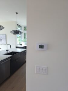 A modern smart thermostat installed on a wall by Excellence Heating & Cooling, LLC. in Beaverton, OR.