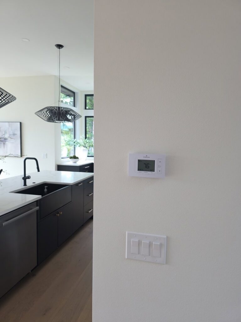 A modern smart thermostat installed on a wall by Excellence Heating & Cooling, LLC. in Beaverton, OR.