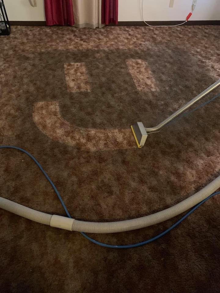 A carpet being cleaned, showing a smiley face pattern created by the cleaning process, by Humble Brothers Carpet Cleaning in Durham, NC.