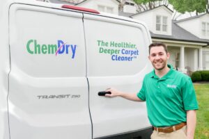 A smiling Chem-Dry of Sioux Falls technician standing next to a company van, ready for service in Sioux Falls, SD.