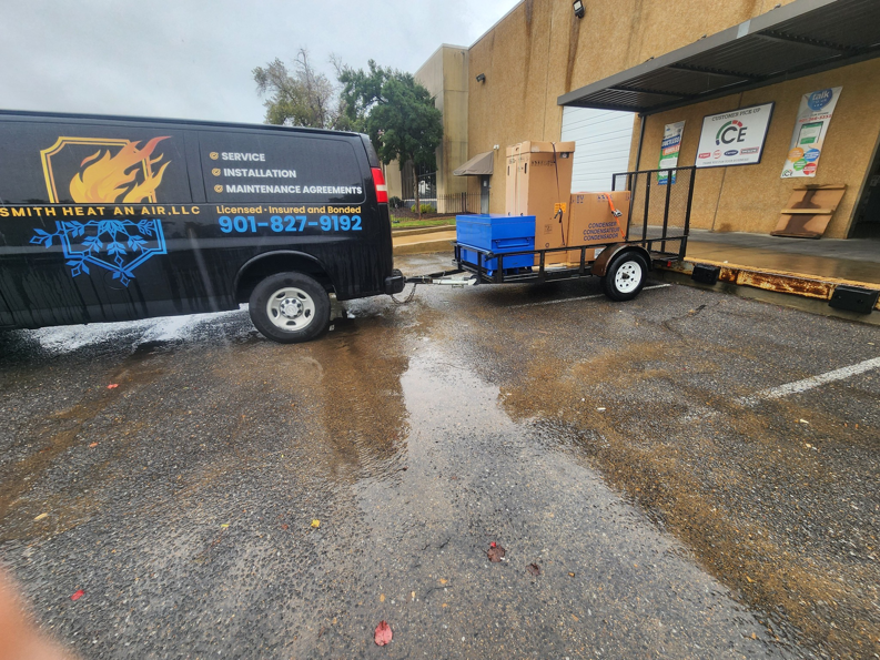 Smith Heat an Air, LLC company van delivering new HVAC condenser units on a trailer in Southaven, MS.