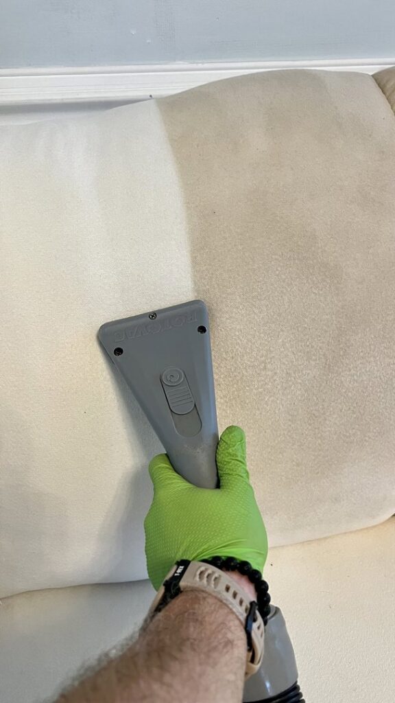 A sofa cushion being professionally cleaned with an upholstery tool by Pronto And Carpet LLC in Charlotte, NC.