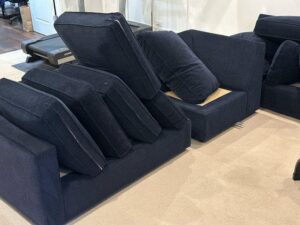 A sofa with cushions removed on a carpeted floor, indicating cleaning by Anderson Certified, INC. in Chicago, IL.