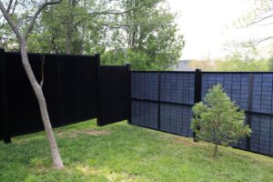 A solar fence with a gate opening in a residential setting, installed by Sol Fence LLC in Evansville, IN.