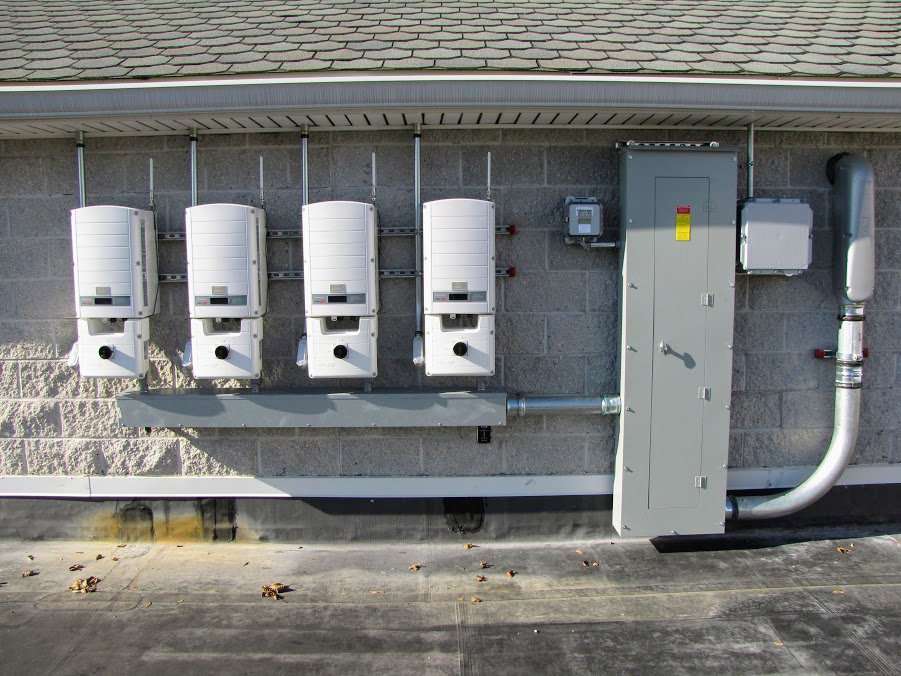 Solar inverters and electrical panel installation on a building by CMI Solar & Electric, Inc. in Newark, DE.