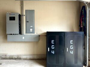 A garage showing a Sol-Ark solar inverter, electrical panel, and EC4 battery storage units installed by Premier Power in Edmond, OK.