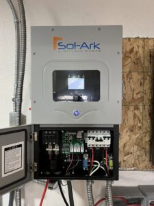 An open Sol-Ark solar inverter and control panel showing internal wiring and breakers, installed by Mountain Electric in Knoxville, TN.