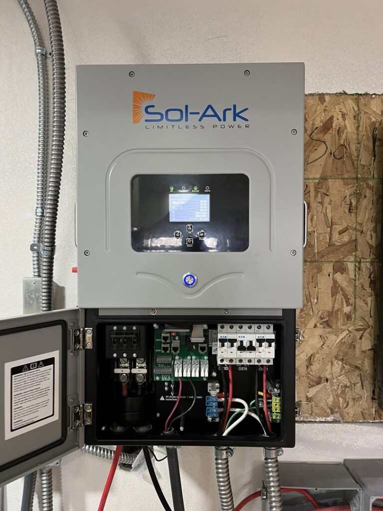 An open Sol-Ark solar inverter and control panel showing internal wiring and breakers, installed by Mountain Electric in Knoxville, TN.