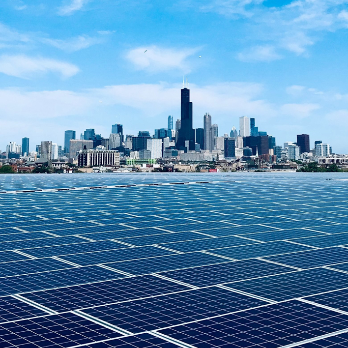 A large-scale solar panel installation with the Chicago skyline in the background, a project type handled by MKD Electric in Elgin, IL.