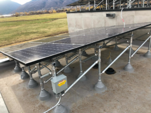Solar panel installation with a visible electrical combiner box on a roof by Pioneer Electric LLC in West Valley City, UT.