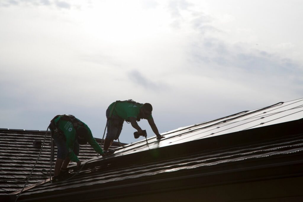 Solar panel installation in progress by electricians from Alternate Energy Inc. on a residential roof in Pearl City, HI.