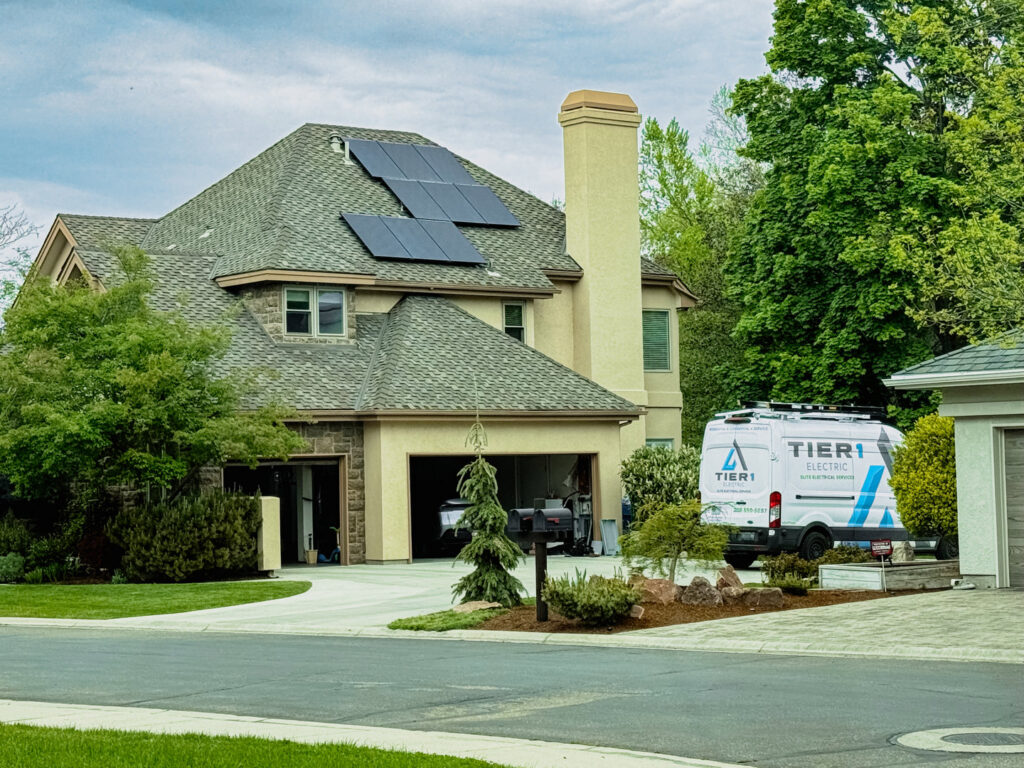 A Tier 1 Electric van parked outside a home with solar panels on the roof, indicating solar service in Boise, ID