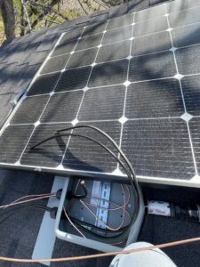 A solar panel installation on a roof with exposed wiring and an electrical box by Rubio Electrical Innovations LLC in San Antonio, TX.
