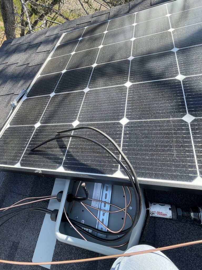A solar panel installation on a roof with exposed wiring and an electrical box by Rubio Electrical Innovations LLC in San Antonio, TX.