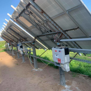 A row of solar panels viewed from behind, showing multiple inverters and electrical connections installed by Affordable Electric, LLC in Kearney, NE.