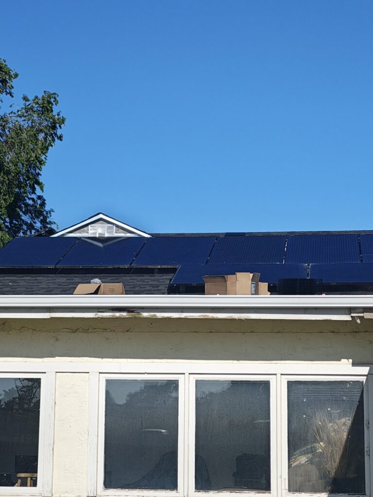 Solar panels being installed on a residential rooftop, showing the installation process by Pueblo Electrics, Inc. in Pueblo, CO.