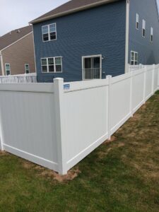 A solid white vinyl privacy fence installed along a property line by A Freedom Fence in Martinsburg, WV.