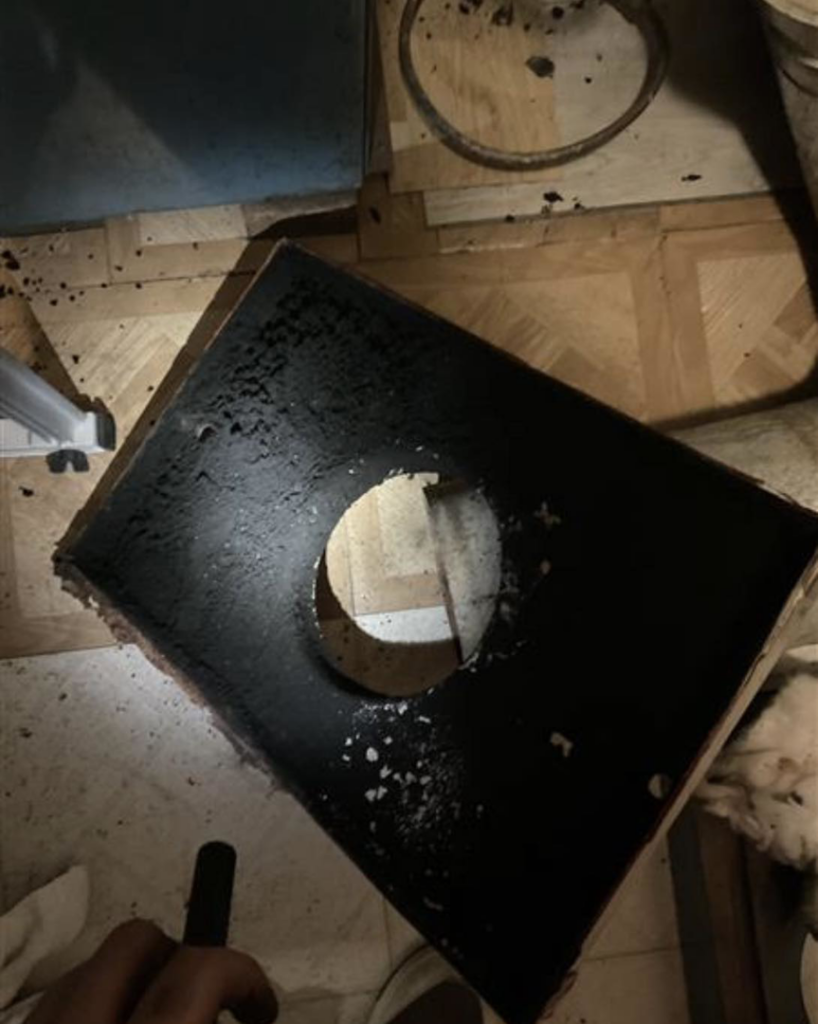 A sooty furnace or boiler component removed for cleaning by Black Oak HVAC in Derry, NH