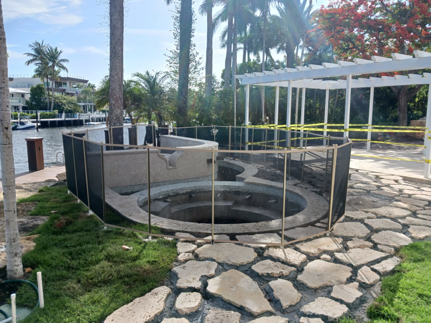 A mesh safety fence installed around a spa and pool area by All Brand Pool Fence in Fort Lauderdale, FL.